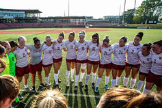 IUK women's soccer team gather in circle.